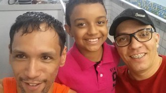 O menino com seus pais Fernando Luiz e Marcelo Pereira